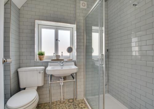 a bathroom with a toilet and a sink and a shower at Corner Cottage in Brighton & Hove