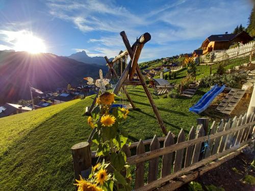 Ein Zaun mit Blumen auf einem Hügel in der Unterkunft Lüch de Crusteles in Wengen