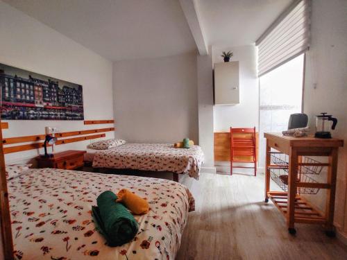 1 dormitorio con 2 camas, escritorio y ventana en Pension Candelaria, en Valle Gran Rey