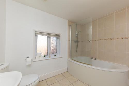 La salle de bains est pourvue d'une baignoire, de toilettes et d'un lavabo. dans l'établissement Rocester Rest close to Alton Towers & JCB, Netflix, à Rocester