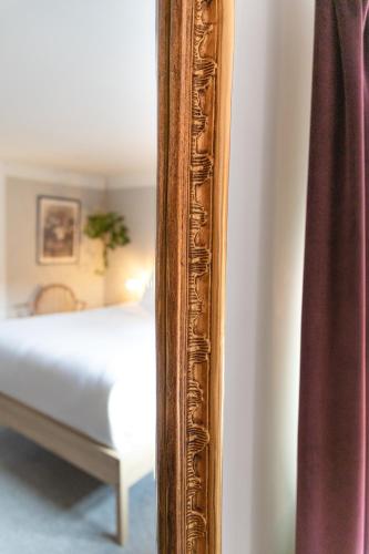 a mirror on a wall next to a bed at House Arundel in Arundel
