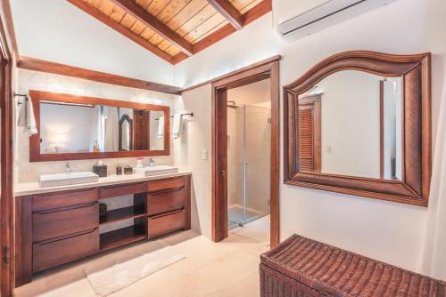 łazienka z 2 umywalkami i lustrem w obiekcie Fun in the sun classic villa at Los Lagos in Casa de Campo w mieście Las Minas