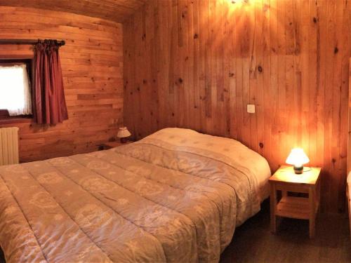 ein Schlafzimmer mit einem Bett in einer Holzhütte in der Unterkunft 2 Pièces 6 Pers Sud à 150m des Pistes - FR-1-416-4 in La Toussuire