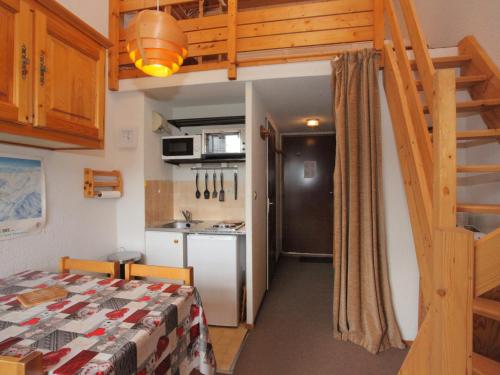 Cette petite chambre comprend un lit et une cuisine. dans l'établissement Studio lumineux et fonctionnel, 2ème étage, 4 pers, skis aux pieds, balcon exposé Sud, près télésiège - FR-1-416-56, à La Toussuire