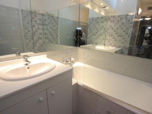 W łazience znajduje się umywalka i lustro. w obiekcie Appartement La Toussuire, 2 pièces, 6 personnes - FR-1-416-64 w mieście La Toussuire