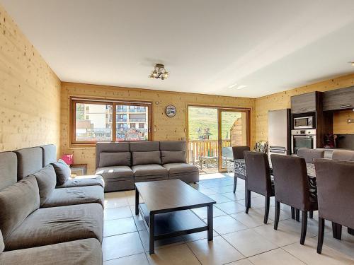 un salon avec des canapés et une table ainsi qu'une cuisine dans l'établissement Magnifique appartement 3 chambres, balcon sud, parking, non-fumeur - FR-1-416-75, à La Toussuire