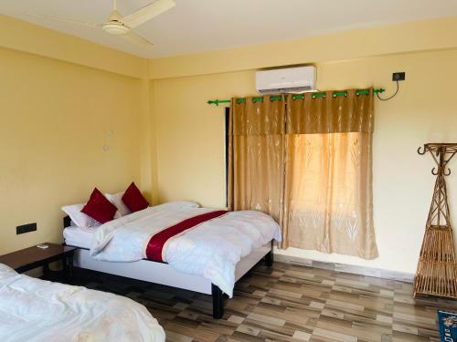 sypialnia z 2 łóżkami i oknem w obiekcie Hotel Happy Land w mieście Chitwan