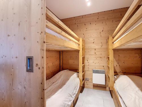 two bunk beds in a room with wooden walls at Magnifique appartement 3 chambres, balcon sud, parking, non-fumeur - FR-1-416-75 in La Toussuire