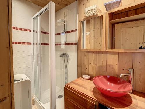 ein Badezimmer mit einem roten Waschbecken auf einer Holztheke in der Unterkunft Appartement moderne 3* 8 pers, 46 m², Sud, proche pistes - FR-1-416-78 in La Toussuire