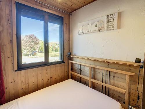 ein Schlafzimmer mit einem Bett und einem Fenster in der Unterkunft Appartement moderne 3* 8 pers, 46 m², Sud, proche pistes - FR-1-416-78 in La Toussuire