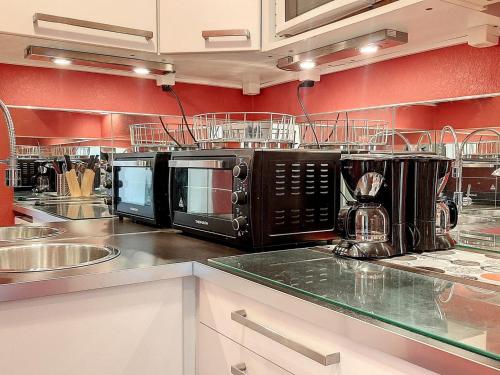 - une cuisine avec 3 fours micro-ondes sur un comptoir dans l'établissement Studio rénové à 80m des pistes, 4 pers, balcon sud et cuisine indépendante - FR-1-416-103, à La Toussuire