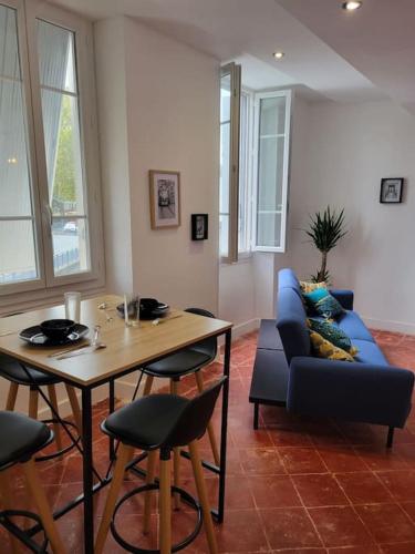 sala de estar con sofá azul y mesa en Appartement de Charme avec tomettes et Parquet, en Graulhet