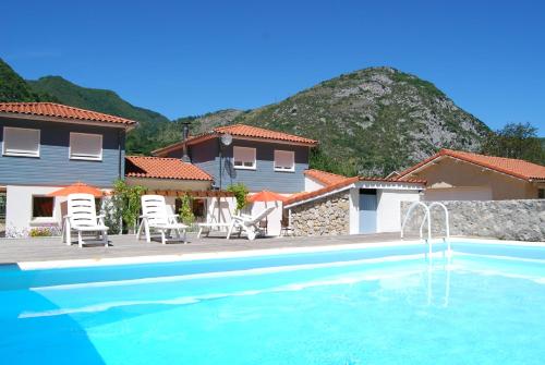 une villa avec une piscine et une maison dans l'établissement Les Terrasses De Castelmerle, à Niaux