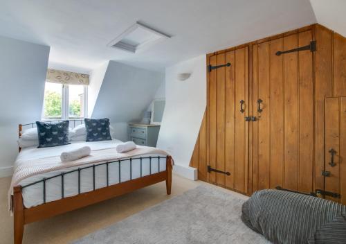 a bedroom with a bed and a large wooden cabinet at Pebble Beach Cottage in Rottingdean