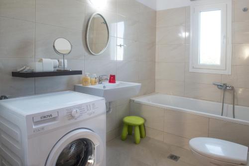 a bathroom with a washing machine and a bath tub at IRIS HOME 4 in Paralia Katerinis