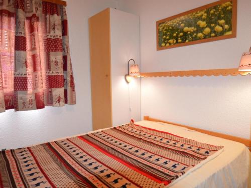 - une chambre avec un lit et une couverture dans l'établissement Appartement Les Menuires, 2 pièces, 4 personnes - FR-1-452-28, aux Menuires