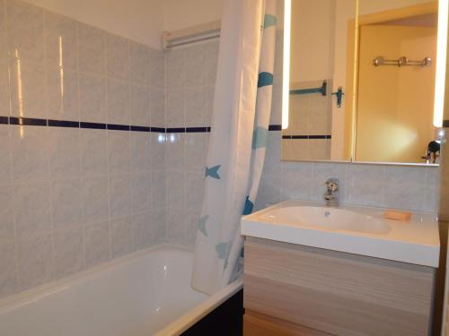 ein Badezimmer mit einer weißen Badewanne und einem Waschbecken in der Unterkunft Appartement Les Menuires, 2 pièces, 4 personnes - FR-1-452-28 in Les Menuires