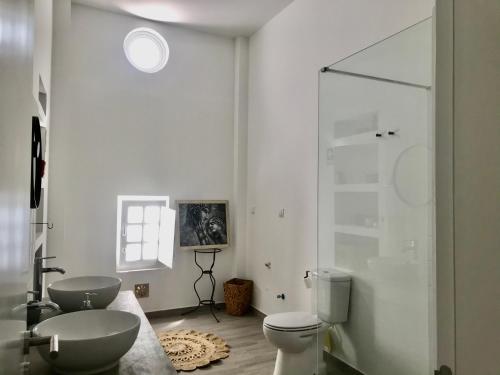 uma casa de banho com um WC e uma cabina de duche em vidro. em Casa do Reguengo 2 em Estremoz