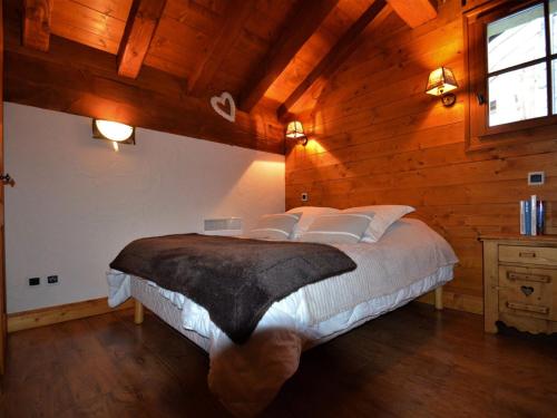 サン・マルタン・ド・ベルヴィルにあるAppartement Saint-Martin-de-Belleville-Les Menuires, 3 pièces, 4 personnes - FR-1-452-60の木製の部屋にベッド1台が備わるベッドルーム1室があります。