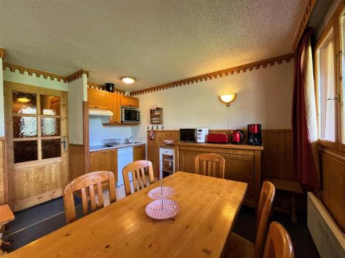 une cuisine avec une table et des chaises en bois dans l'établissement Appartement Confort 6 Personnes, Pied des Pistes, 3 Pièces, Reberty 1850 - FR-1-452-126, aux Menuires