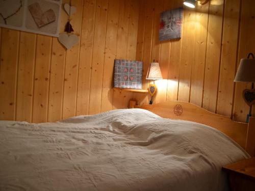 レ・メニュアールにあるAppartement Les Menuires, 2 pièces, 4 personnes - FR-1-452-155の木製の壁のベッドルーム1室(大型ベッド1台付)