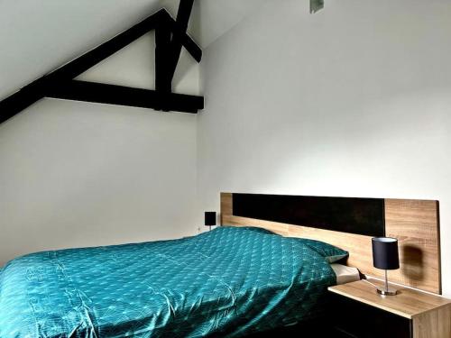 1 dormitorio con 1 cama con edredón azul en La Parisienne - 80m2, en Vierzon