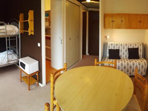 une chambre avec une table en bois et une chambre avec un lit dans l'établissement Studio 4 pers. avec balcon sud, proche pistes et commerces, tout équipé - FR-1-416-181, à La Toussuire