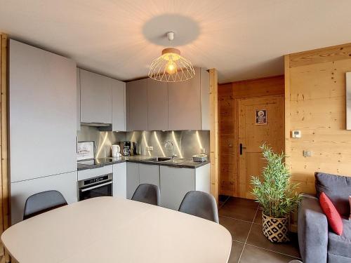 une cuisine et une salle à manger avec une table et des chaises dans l'établissement Appartement neuf pour 6 pers. avec parking, balcon et sur pistes - FR-1-416-186, à La Toussuire