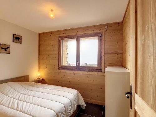 a bedroom with a bed and a window at Appartement neuf pour 6 pers. avec parking, balcon et sur pistes - FR-1-416-186 in La Toussuire