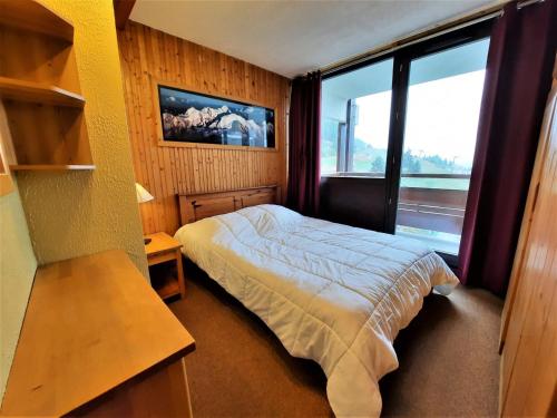 une chambre avec un lit et une grande fenêtre dans l'établissement Appartement cosy 5 pers. au pied des pistes, Les Ménuires - Balcon, animaux acceptés - FR-1-452-131, aux Menuires