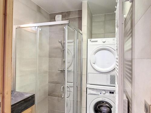 une salle de bain avec une machine à laver et un lave-linge dans l'établissement Bel appartement sur les pistes avec parking, balcon et équipements modernes - FR-1-416-190, à La Toussuire