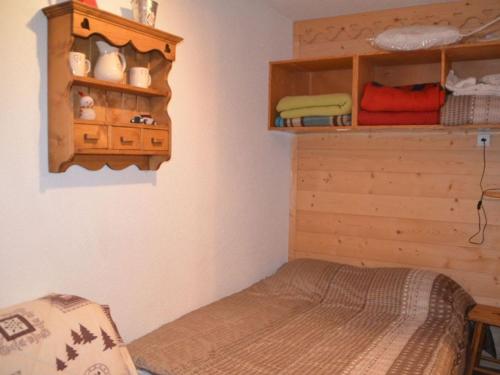 レ・メニュアールにあるAppartement Les Menuires, 1 pièce, 4 personnes - FR-1-452-137のベッドルーム1室(ベッド1台付)、木製キャビネットが備わります。