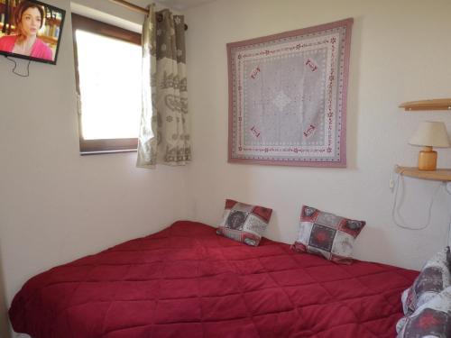 - un lit rouge dans une chambre avec fenêtre dans l'établissement Appartement Les Menuires, 3 pièces, 5 personnes - FR-1-452-237, aux Menuires