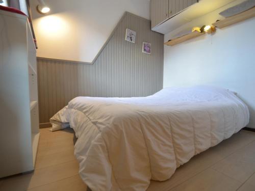 Un dormitorio con una cama con una manta blanca. en Studio Les Menuires, 1 pièce, 4 personnes - FR-1-452-262 en Les Menuires