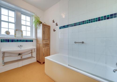 La salle de bains est pourvue d'une baignoire et d'un lavabo. dans l'établissement Red Doors, à Canterbury