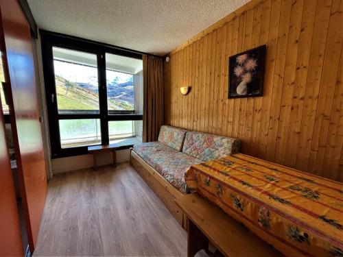 une chambre avec un canapé et une fenêtre dans l'établissement Studio confortable pour 4 personnes avec balcon et animaux admis - FR-1-452-187, aux Menuires