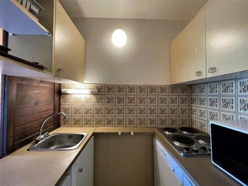une petite cuisine avec un évier et une cuisinière dans l'établissement Studio confortable pour 4 personnes avec balcon et animaux admis - FR-1-452-187, aux Menuires
