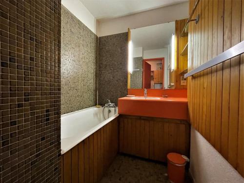 ein Badezimmer mit einer Badewanne, einem Waschbecken und einem Spiegel in der Unterkunft Studio Les Menuires, 1 pièce, 4 personnes - FR-1-452-190 in Les Menuires