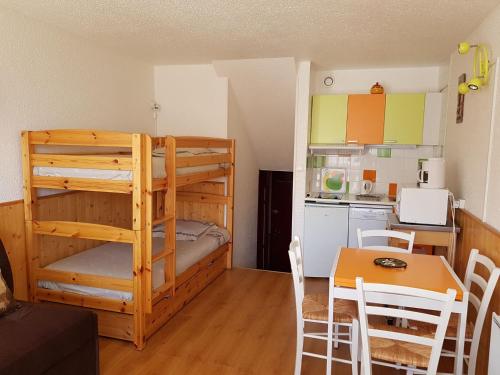 Cette chambre comprend des lits superposés, une table et une cuisine. dans l'établissement Studio confortable aux Menuires pour 3 personnes avec balcon - FR-1-452-227, aux Menuires