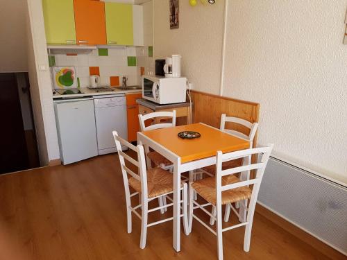 une cuisine avec une table et des chaises dans une pièce dans l'établissement Studio confortable aux Menuires pour 3 personnes avec balcon - FR-1-452-227, aux Menuires