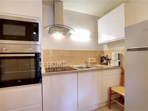 une cuisine avec des armoires blanches et un évier dans l'établissement Charmant 2.5 pièces à Courchevel Village - Près des pistes, pour 4 pers., label charme 9/10 - FR-1-575-67, à Courchevel