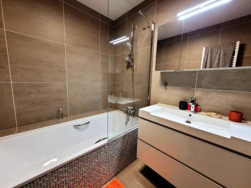 La salle de bains est pourvue d'un lavabo, d'une baignoire et d'un miroir. dans l'établissement Appartement Les Gets, 4 pièces, 6 personnes - FR-1-598-37, aux Gets