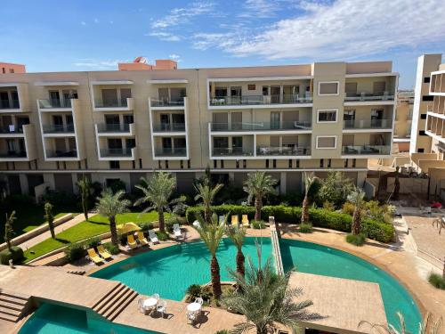 een appartementencomplex met een zwembad en palmbomen bij The pearl garden vu piscine in Marrakesh