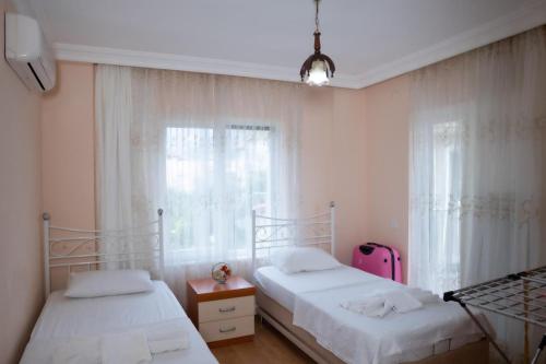 a bedroom with two beds and a pink suitcase at Villa Cozy in Marmaris