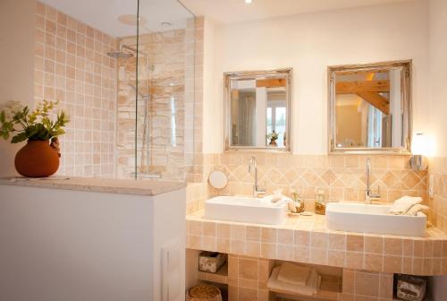 a bathroom with two sinks and two mirrors at Les 4 éléments in Tourrettes-sur-Loup