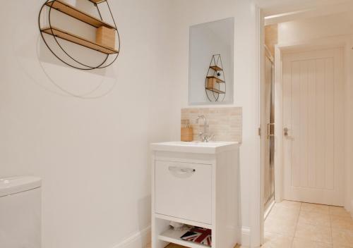 ein Badezimmer mit einem weißen Waschbecken und einem Spiegel in der Unterkunft Little Bourne in Tonbridge