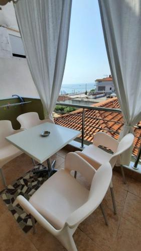 a balcony with a table and chairs and a view of the ocean at Oniro Rooms & Suites in Leptokaria