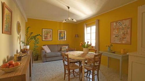 een woonkamer met een tafel en een bank bij Au coin de la Roquette in Arles