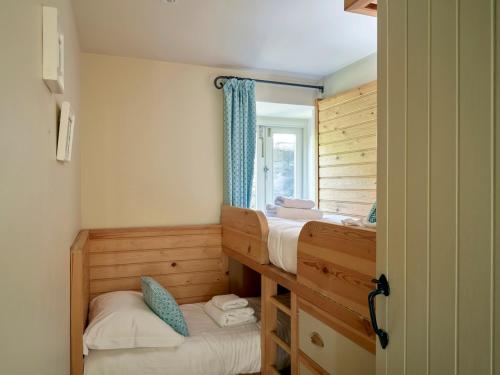 1 Schlafzimmer mit 2 Etagenbetten und einem Fenster in der Unterkunft Maristow Cottage in Totnes