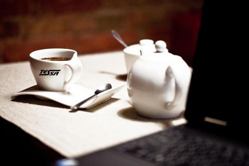a table with a cup of coffee and a tea pot at Pokoje Gościnne Tessa in Chełm